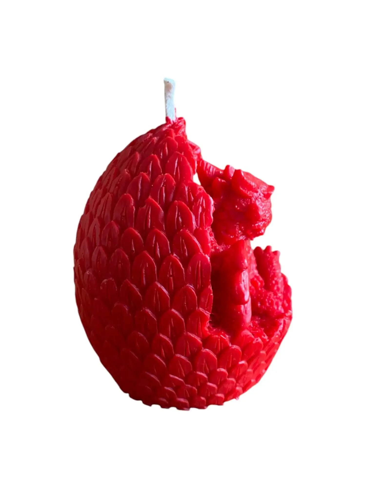 Red wax candle shaped as a dragon hatching from a textured egg with scales